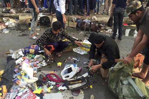Street vendors collect their belongings after deadly bombing attacks in Sadr City, Baghdad, Iraq, Sunday, Feb. 28, 2016. Militants attacked Mredi outdoor market on Sunday in eastern Baghdad, killing at least 24 people and wounding dozens, officials said. Minutes later, a suicide bomber blew himself up amid the crowd that had gathered at the site of the first bombing, he added. (AP Photo/Ali Abdul Hassan)